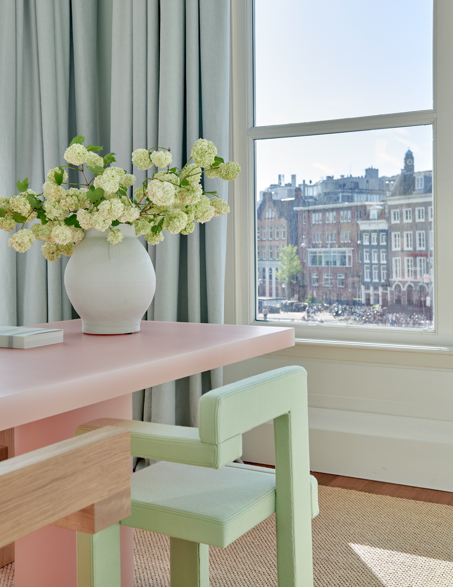 View from the Gloobles Suite at De L’Europe Amsterdam, showcasing picturesque canal houses and cityscape.