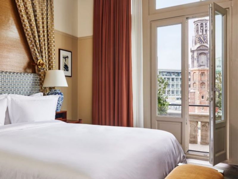 Cama situada cerca de las puertas del balcón que ofrecen una vista despejada de la Torre Munt.