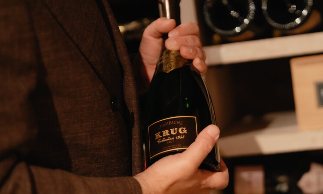 Sommelier holding a bottle of Krug champagne in the wine cellar