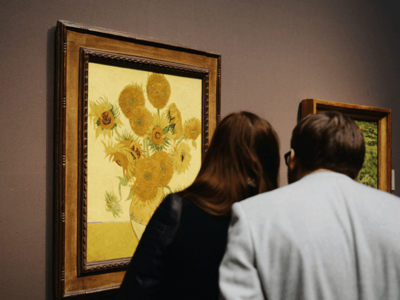 Museum visitors looking at a painting of Van Gigh